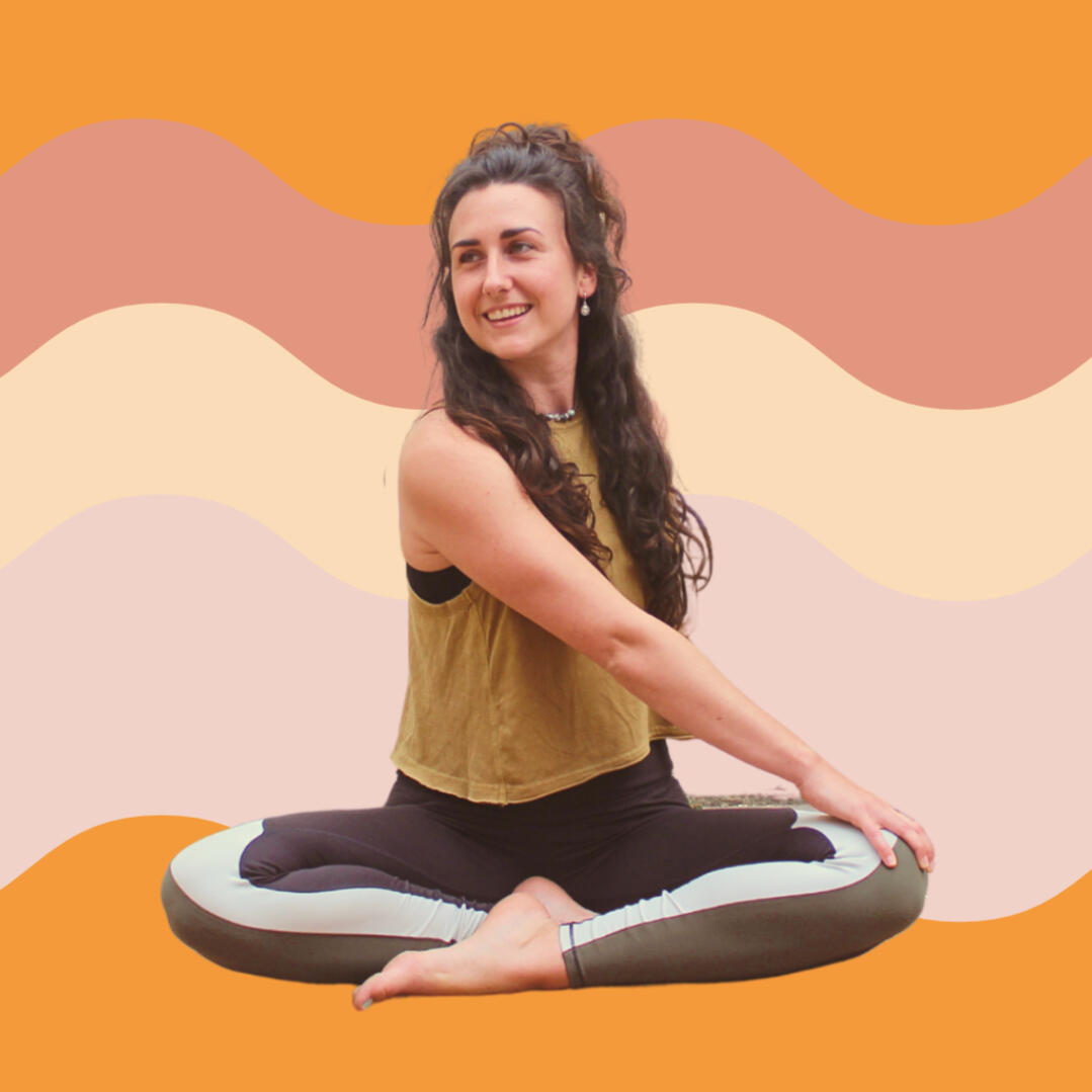 Yoga photo 3 A photo of Liv in a yoga position. She is sat with her legs crossed, one hand crosses her body and rests on her knee. She is smiling and looking over her shoulder. There is a pink, cream and light purple background.